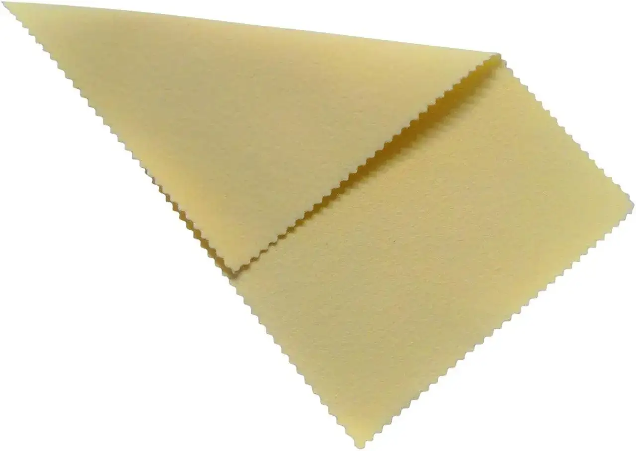 Ein gelbes Mikrofasertuch, ideal zum Messing reinigen, liegt gefaltet auf wei&szlig;em Grund.