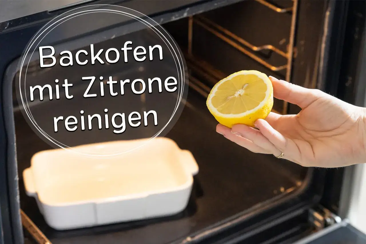 Backofen reinigen mit Zitrone: Eine Hand hält eine halbe Zitrone über einer Auflaufform im dunklen Backofen.