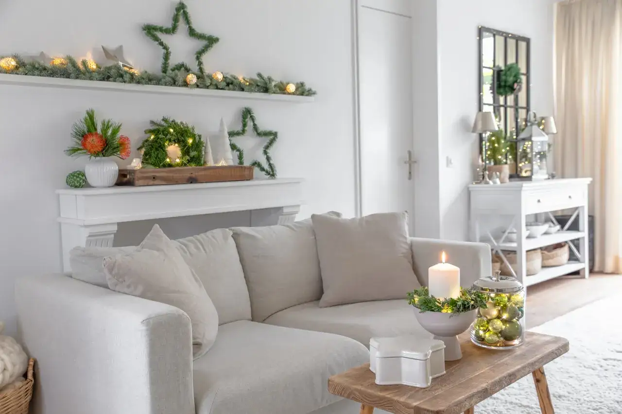 Gem&uuml;tliches Wohnzimmer mit Weihnachtsdeko: Lichterketten, Sterne und Kerzen laden zum Tr&auml;umen ein. Ab wann Weihnachtsdeko? Hier ist die Antwort!