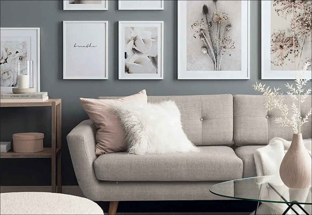 Stilvolle wandgestaltung wohnzimmer hinter couch mit floralen Bildern und dem Wort 