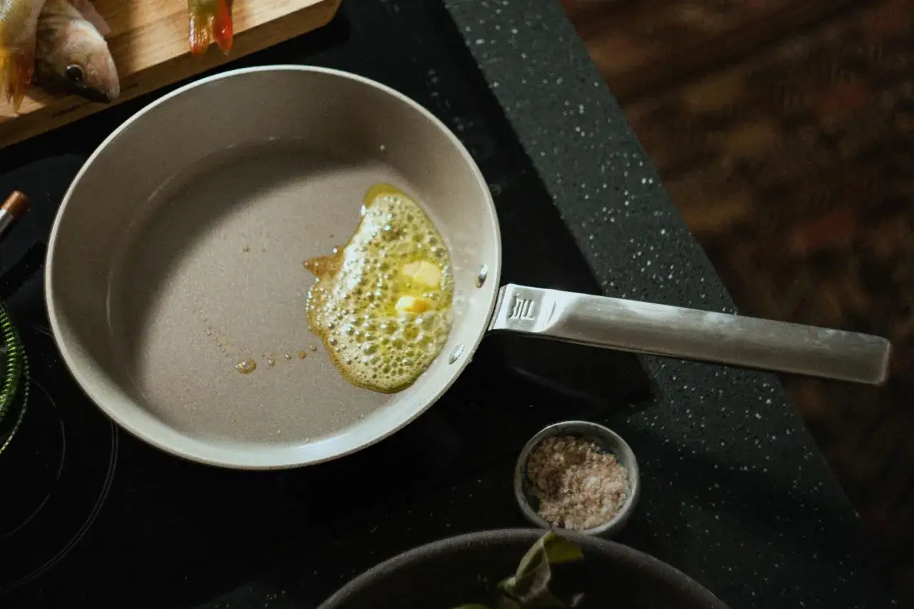 Butter schmilzt in einer beschichteten Pfanne, bereit für die Zubereitung von Fisch.