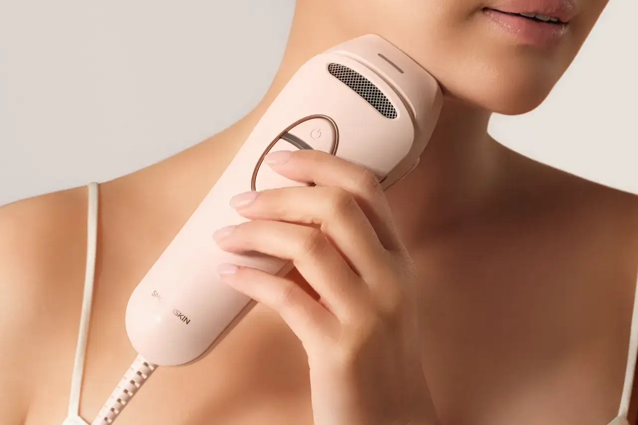 Frau wendet IPL-Gerät am Hals an. Hier sind einige epilieren tipps für glatte Haut.