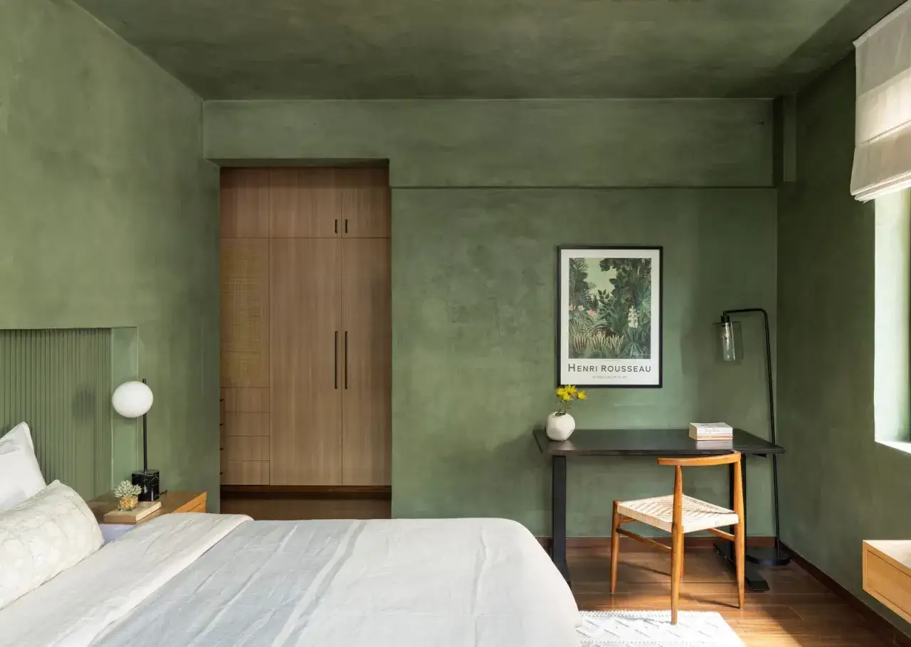 Gr&uuml;nes Feng Shui Schlafzimmer mit Holzeinbauten und einem Schreibtisch mit Kunst.