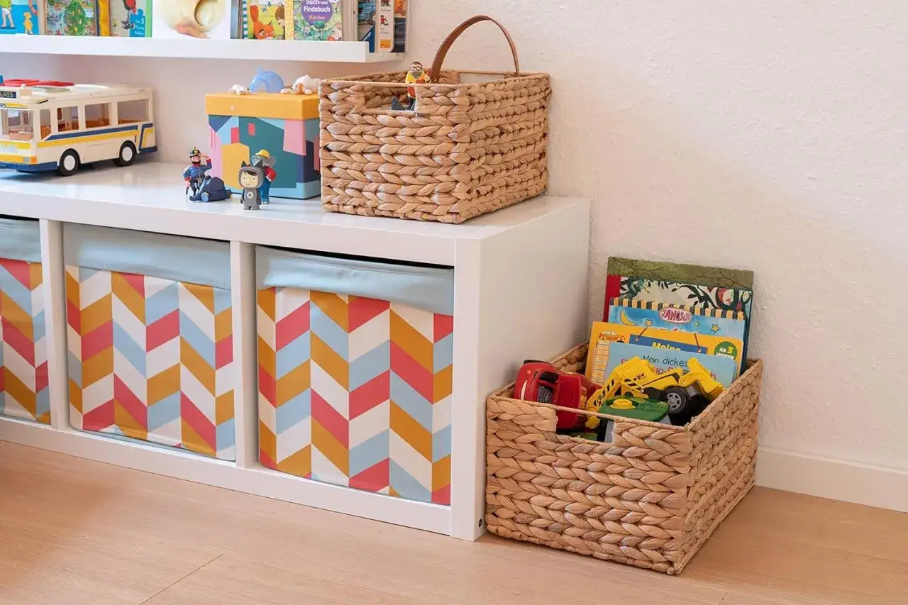 Ordnung im Kinderzimmer: Spielzeugbus, bunte Boxen und Körbe mit Büchern und Autos sorgen für Übersicht.
