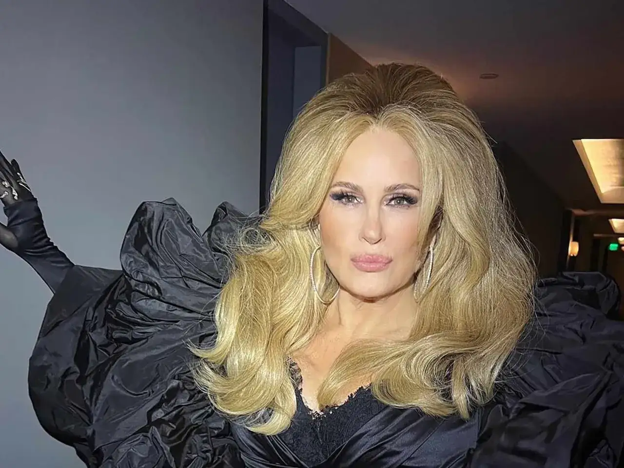 Jennifer Coolidge mit voluminösem, fluffigem Haar und einem dramatischen schwarzen Kleid.