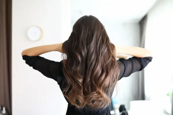 Frauenhaar mit butterfly haircut mittellang, wellig und braun.